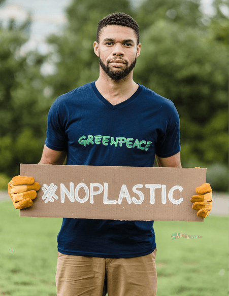 Man holding a 'NO PLASTIC' sign